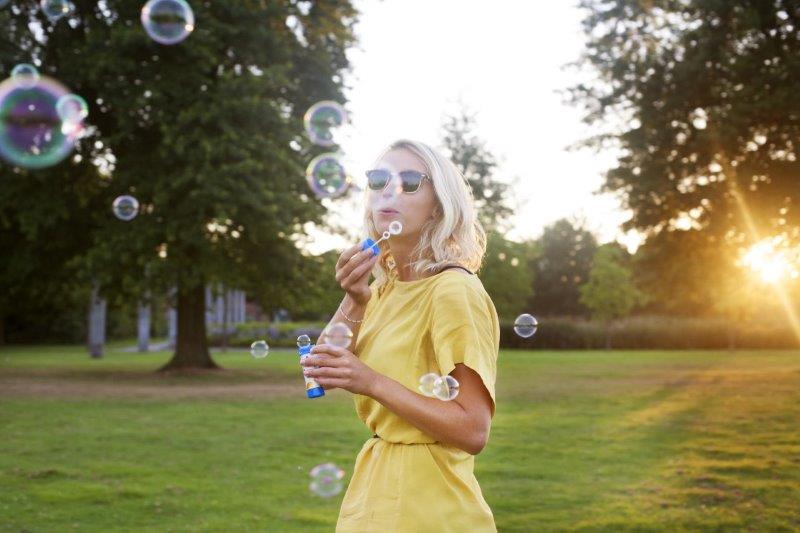 Woman blowing bubbles in yard